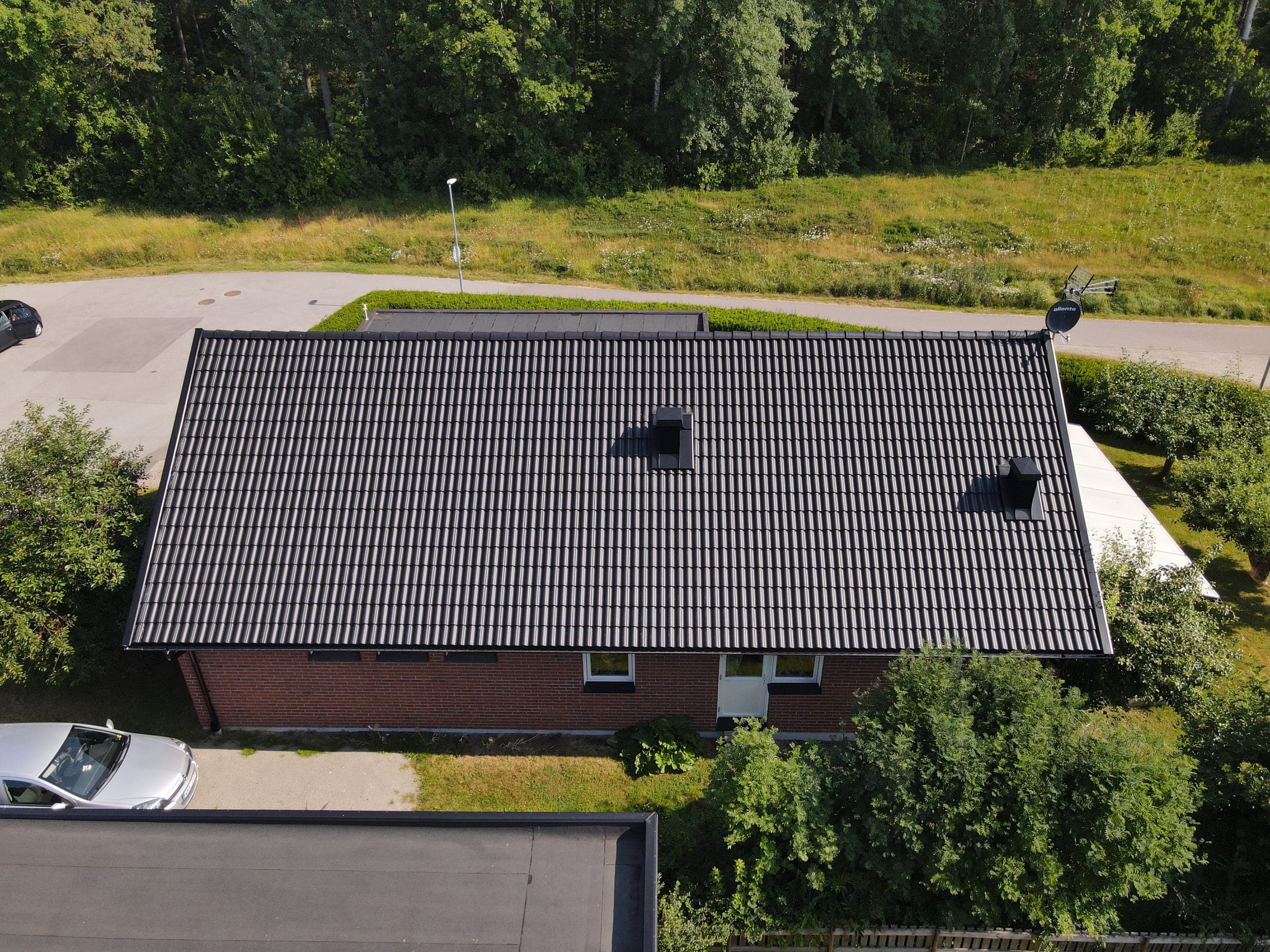 Samma villa i Finspång efter takbytet – nya svarta betongpannor